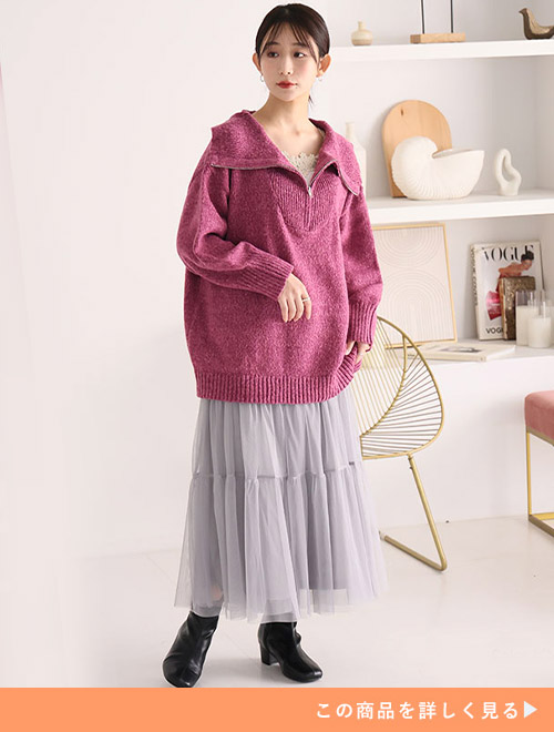 グレーのチュールスカートにピンクのメランジニットを合わせブラックのブーツを履く女性