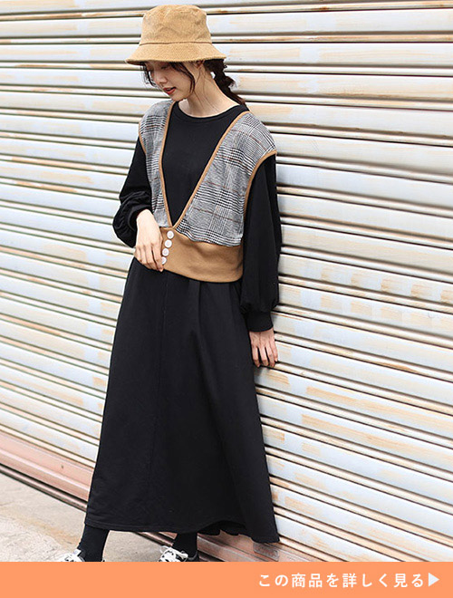 黒のAラインワンピース×茶系のショートベストのセットコーデを着る女性