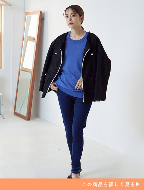 ブルーのトップス×濃色デニムコーデに、黒のツイードジャケットを肩掛けする女性