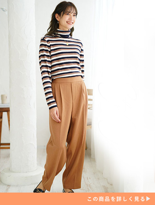 キャメルのタックワイドパンツとマルチボーダートップスのコーデにブラックパンプスを履く女性
