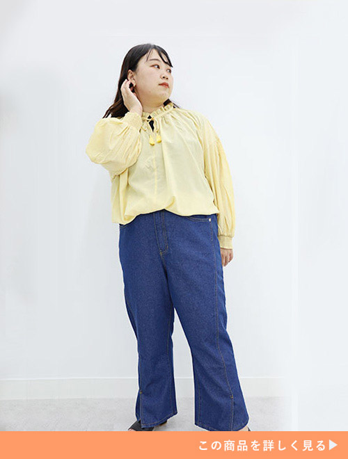 黄色のブラウス×デニムのフレアーパンツをトップスインで着る女性