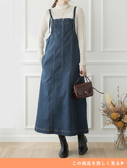 クリーム色のシアートップス×デニムのジャンスカを着る女性