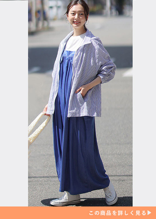 白Tにブルーのジャンスカを着て、ストライプ柄のブルゾンを羽織る女性