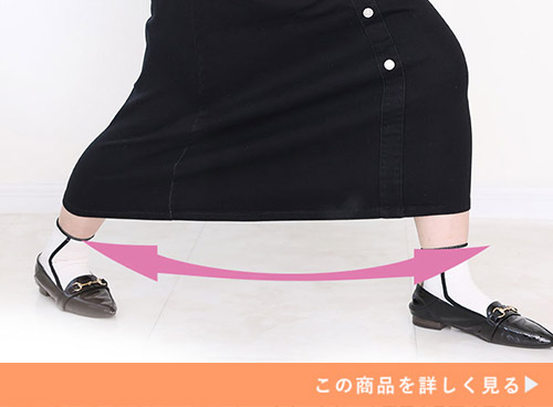 両足を大きく開けるほど伸びる、ストレッチ素材のブラックデニムスカートを履く女性