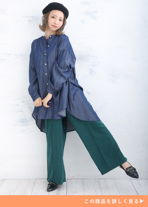デニム風シャツチュニックとダークグリーンのパンツにブラックのベレー帽を合わせる女性