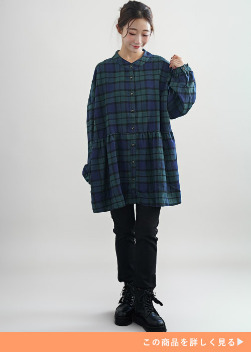 グリーン系のチェック柄チュニック×黒のパンツを着る女性
