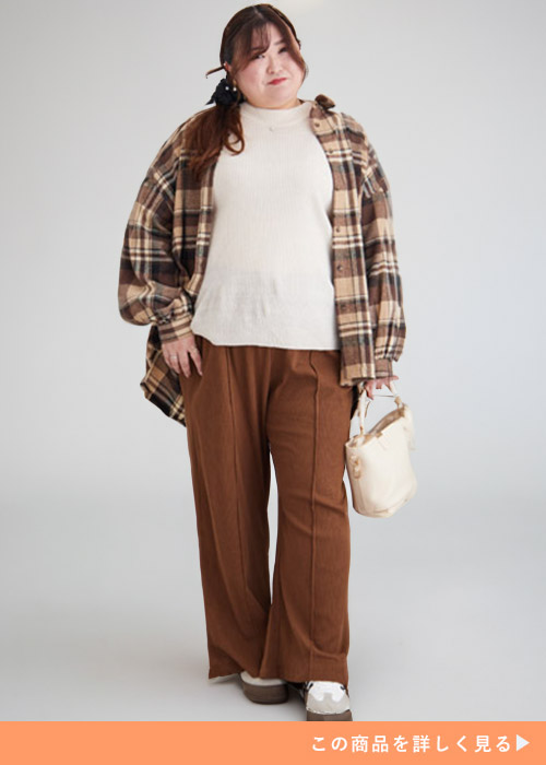 アイボリーのトップス×ブラウンのパンツにグレージュのチェック柄シャツを羽織る女性