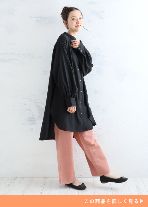 黒のチュニックシャツ×ピンクのパンツを着る女性