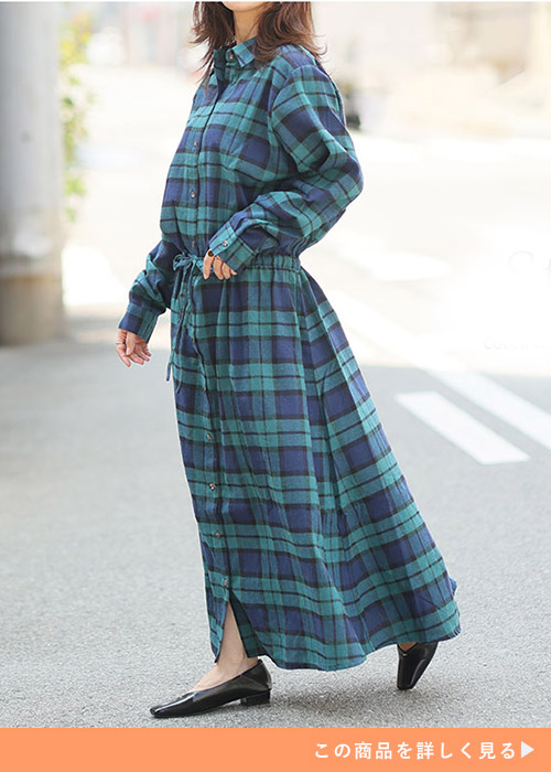 グリーン系のチェック柄ワンピースを着る女性