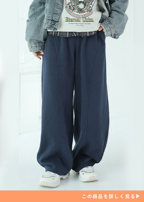 ネイビーのパンツに白T、デニムジャケットを羽織った女性