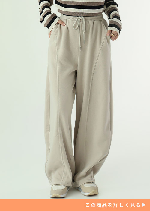 グレージュのスウェットにボーダーのトップスを着る女性